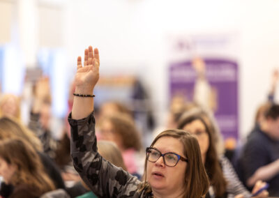 Member raising hand at event